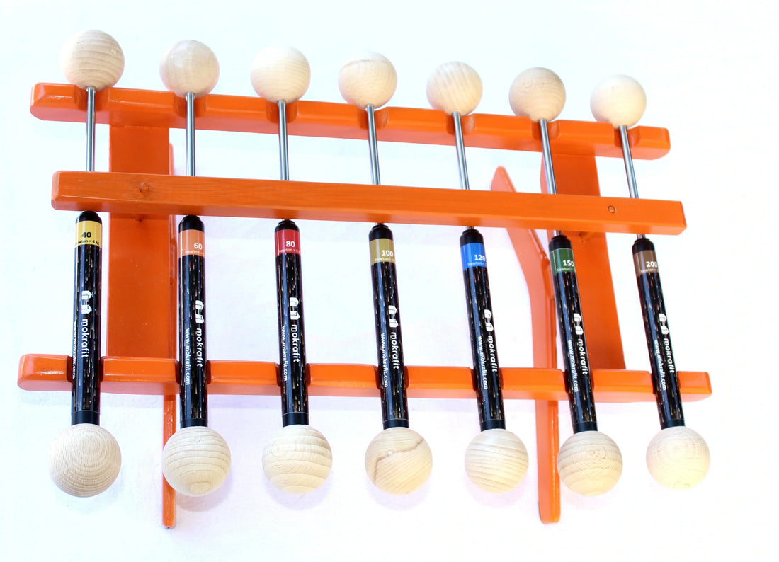 Mokrafit‑PowerSticks (4–20 kg) im Holzgestell, mit farbigen Etiketten zur klaren Kraftstärken‑Kennzeichnung